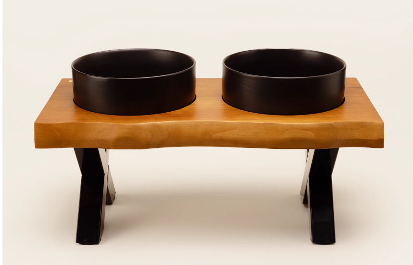 Wooden pet feeder with two black bowls on a white background