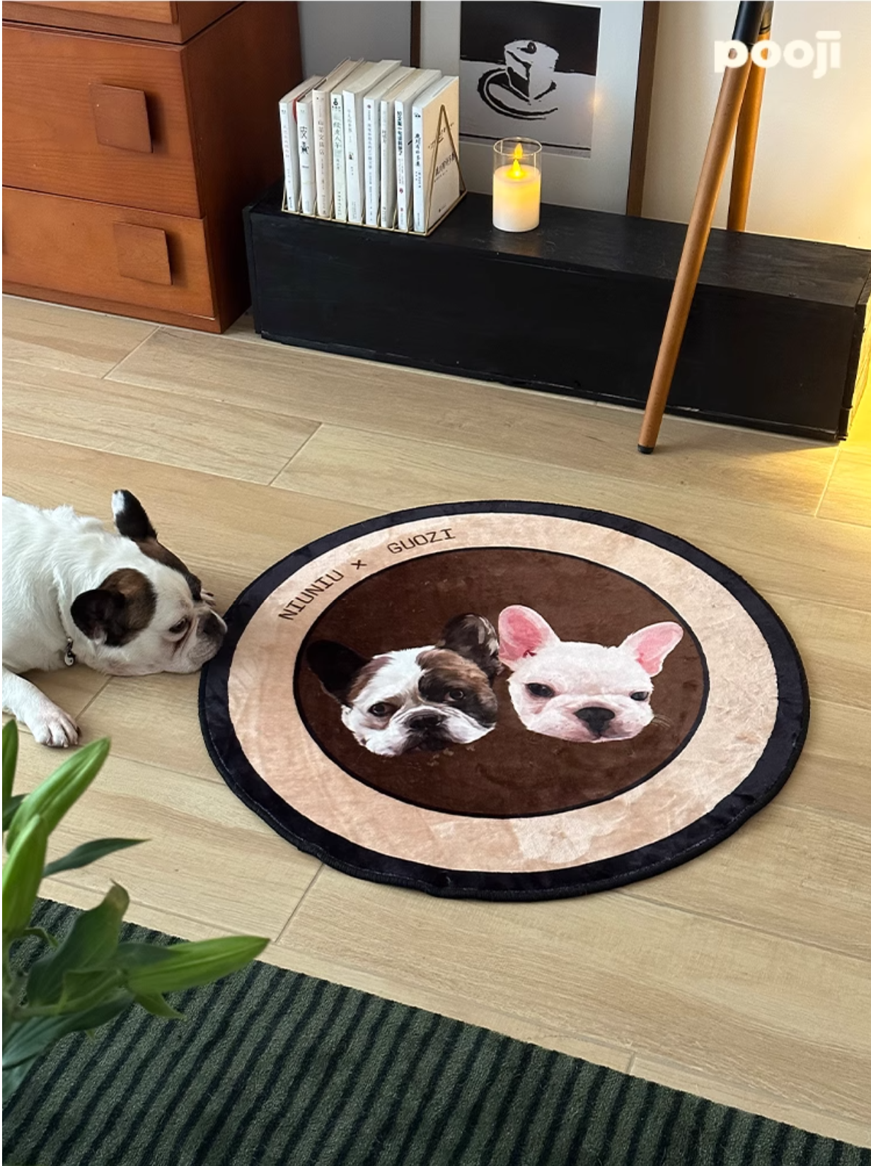Round rug with dog illustrations on a wooden floor, with a dog lying next to it.