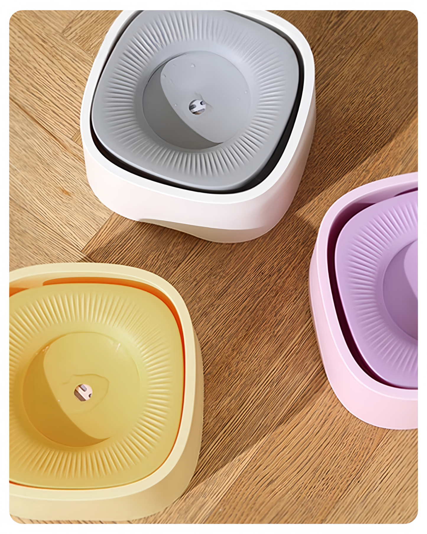 Three kitchen sponges in different colors on a wooden surface