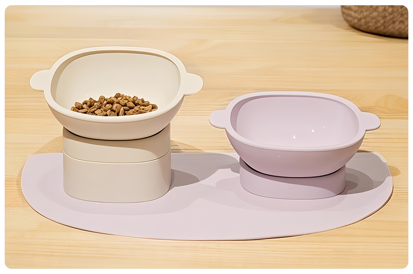 Two pet bowls on a wooden surface with a placemat underneath.