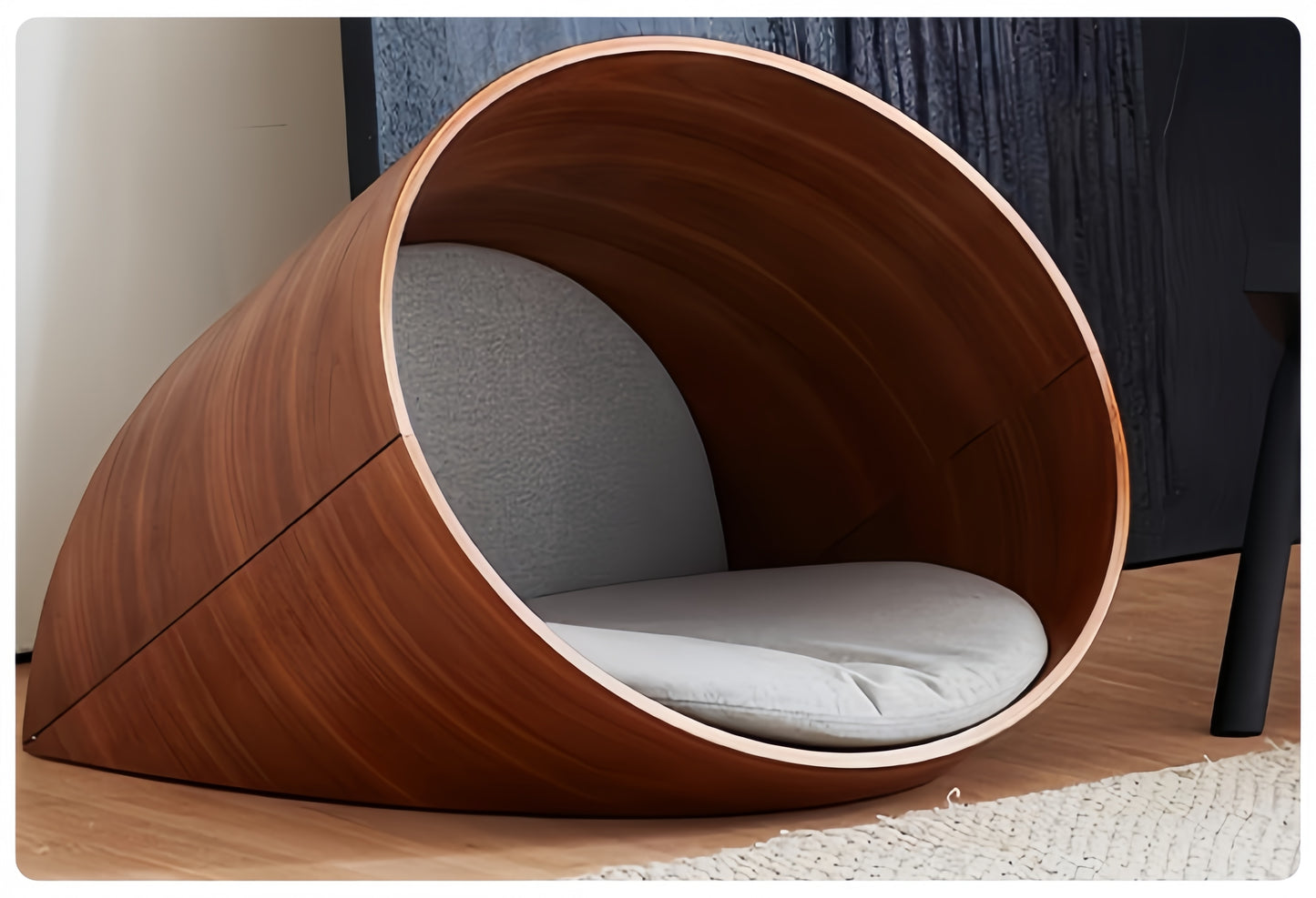 Wooden pet bed with a gray cushion inside, placed on a wooden floor.