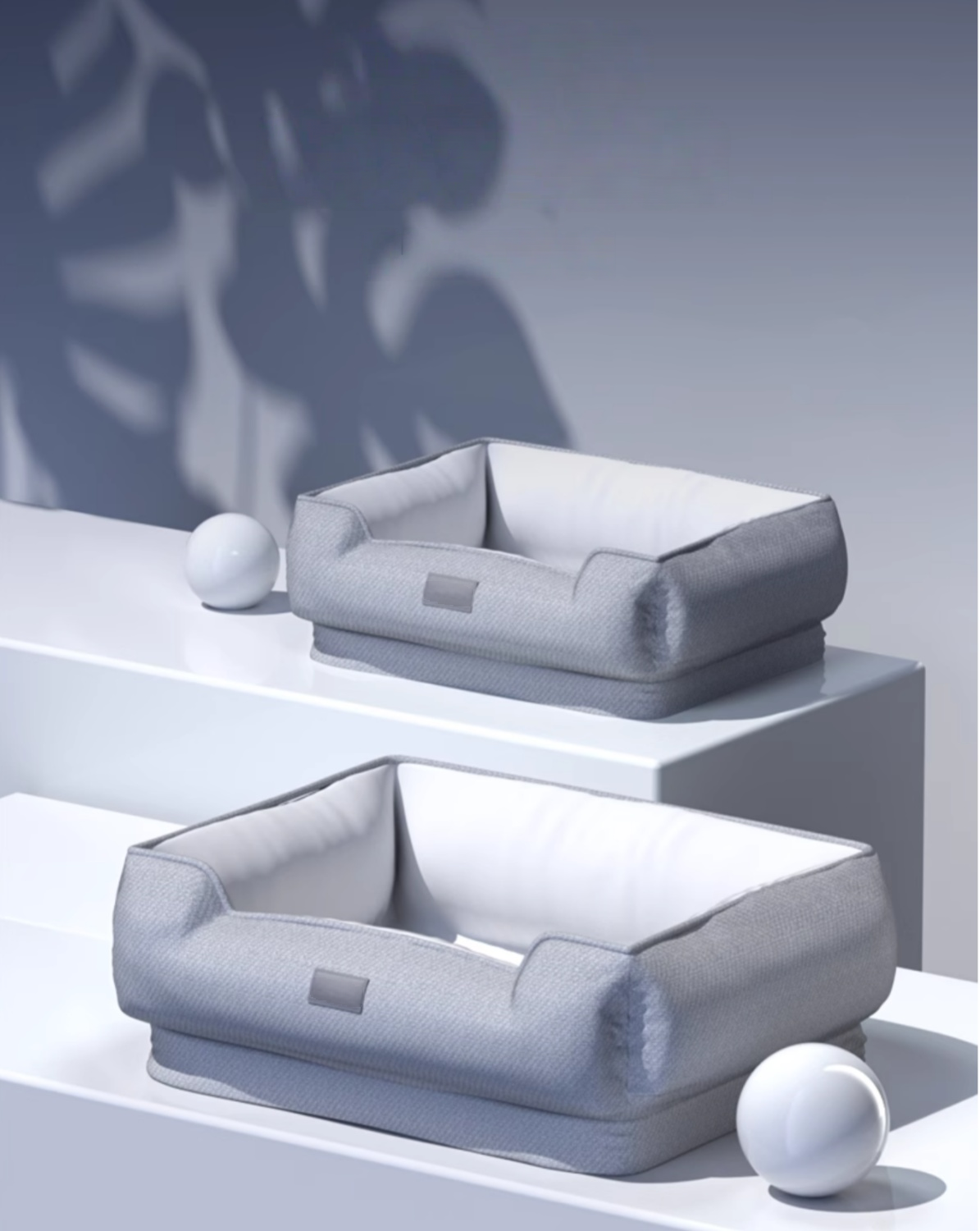 Two gray pet beds on a white surface with a blurred background
